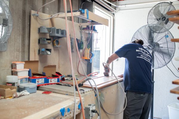 Better Cabinets & Bath craftsman working on a cabinet door in the shop