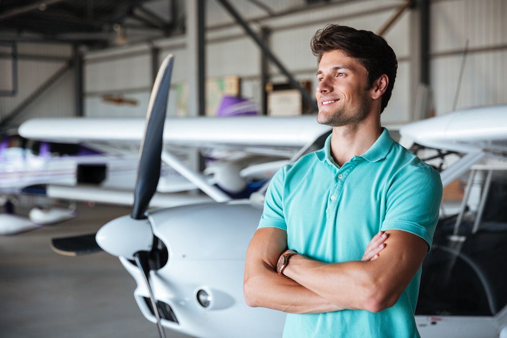 graphicstock-happy-young-man-standing-with-arms-crossed-near-small-airplane_ru8H9SS2e_PMNW.jpg