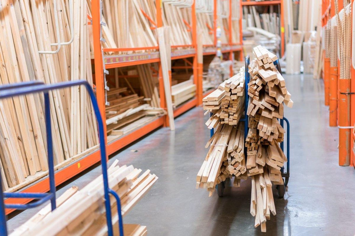 Reuse store aisle stacked with donated lumber, molding, and doors on orange racks