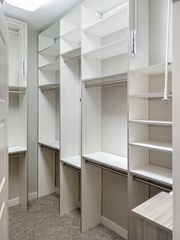 Walk-in closet in Omaha with white TFL finish, open shelving, multiple hanging sections, and corner storage. Walk-In Closet with Shelving and Hanging, Omaha