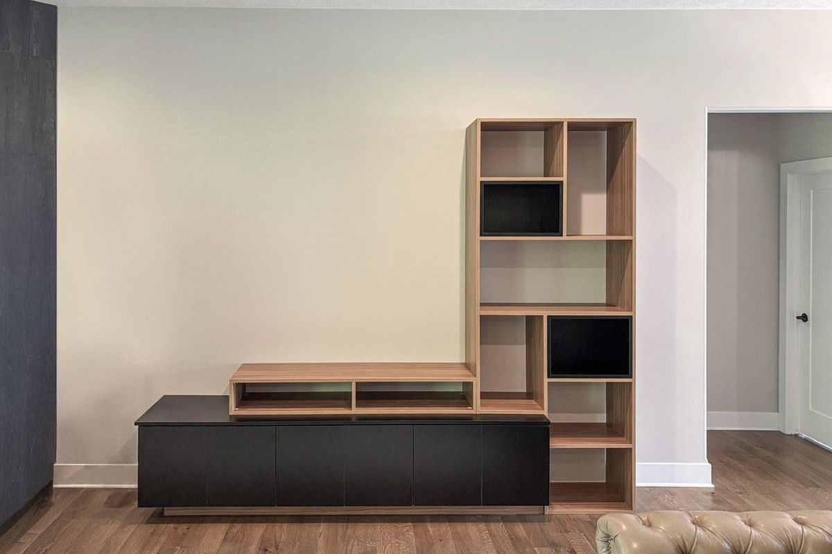 Custom entertainment center with a black low cabinet and open wood shelving in an Omaha living room