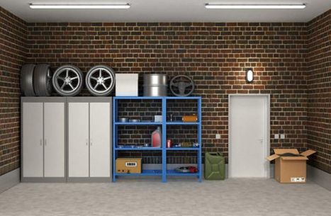 Organized garage with tall white cabinets, blue steel shelving, and stacked tires on a brick wall