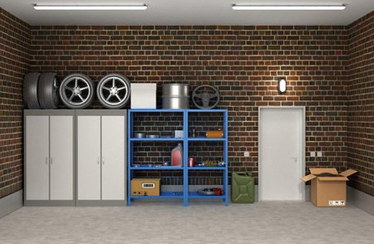 Organized garage with tall white cabinets, blue steel shelving, and stacked tires on a brick wall