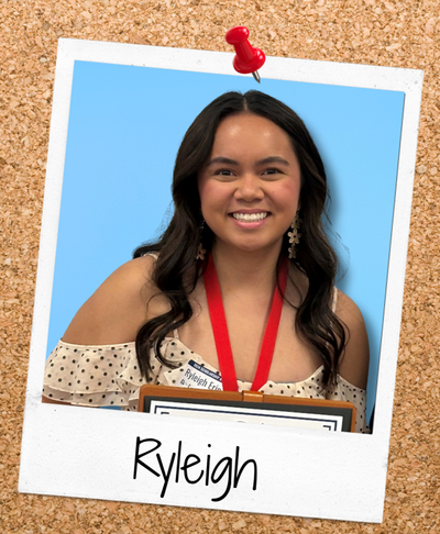 Scholarship student holding an award, pinned to a corkboard