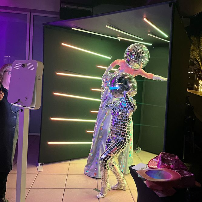 Girls in Mirror Ball Costumes in the Vogue Booth.  One on stilts. 