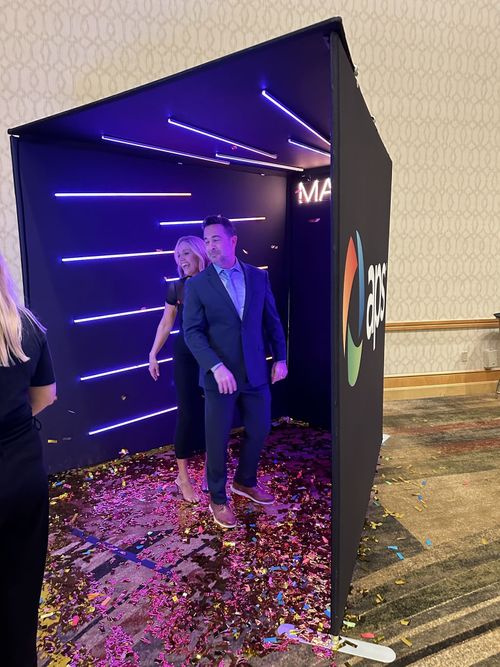 Fun event with the confetti cannon in the Vogue Booth with 22 LED lights. Branded booth with APS logo, Mame customized led light havning in the background.