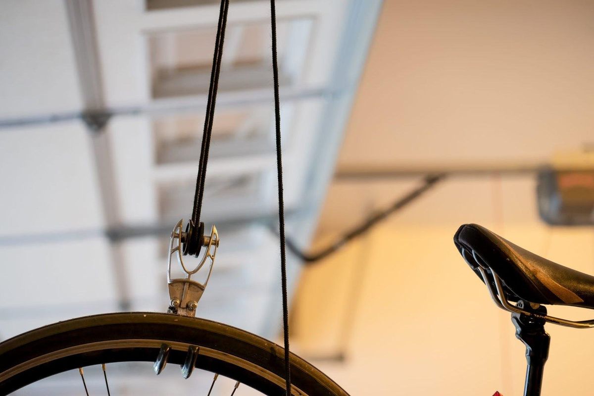 Bicycle hanging from a ceiling-mounted garage storage hook
