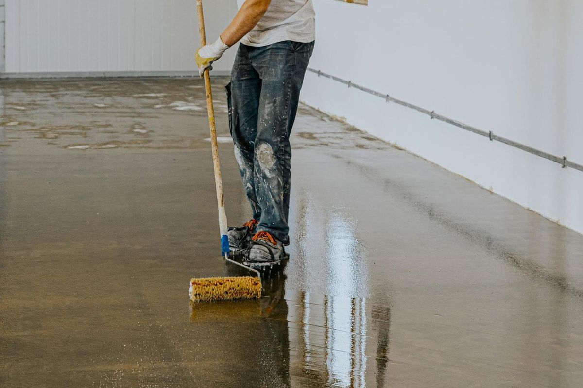 Installer rolling a glossy epoxy coating onto a garage floor